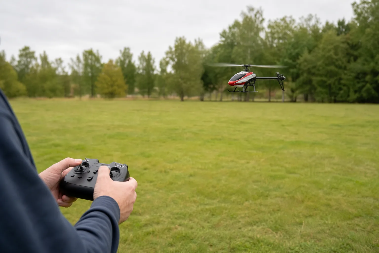 Nybörjare övar svävning med en liten radiostyrd helikopter inomhus i ett rymligt rum