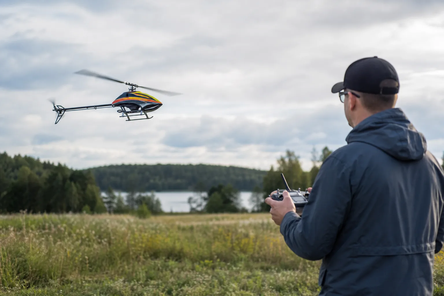 Radiostyrd helikopter flyger stabilt över en öppen gräsyta utomhus
