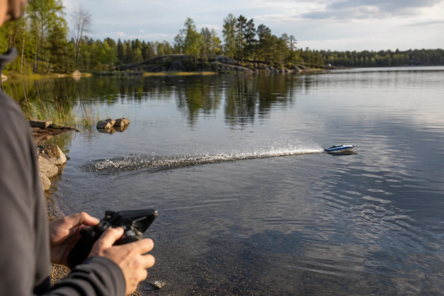 Smal, aerodynamisk radiostyrd racingbåt drar upp fart över öppet vatten