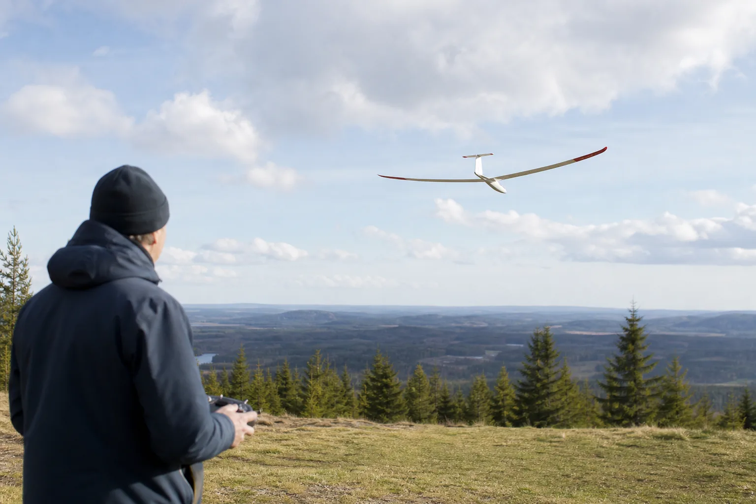 Radiostyrt segelflygplan glider motorlöst över ett öppet fält i medvind