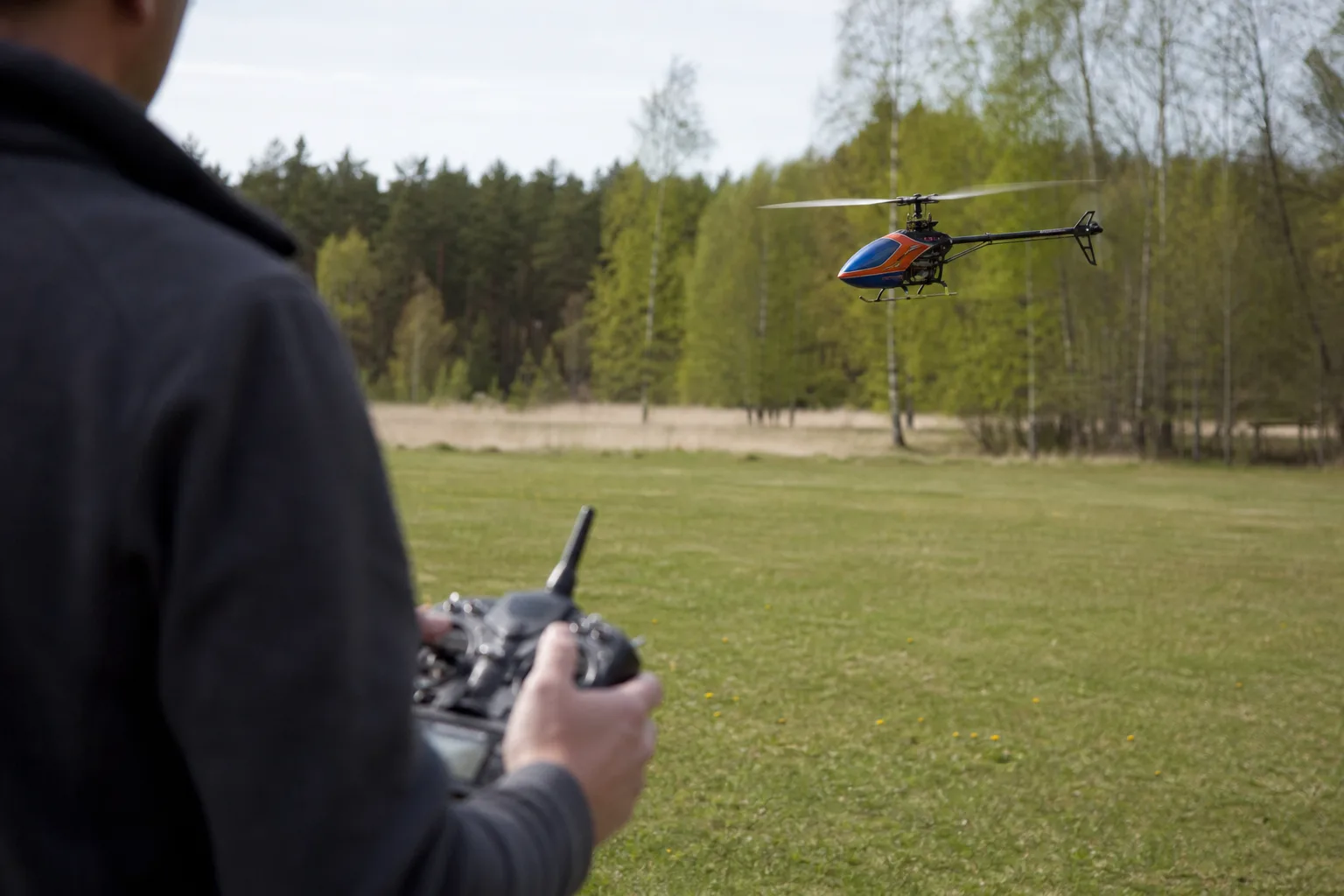 Radiostyrd helikopter svävar stilla inomhus i ett rum med gott om utrymme